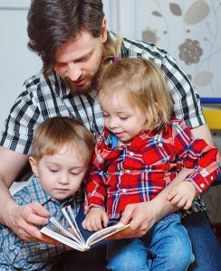 Dad reading to 2 small children
